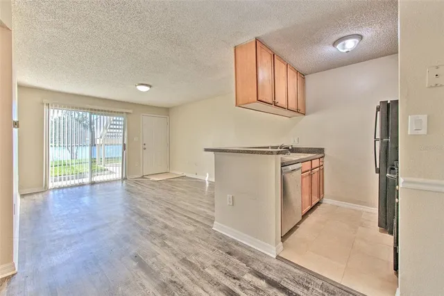 a view of a kitchen with a sink wooden floor and a ceiling fan