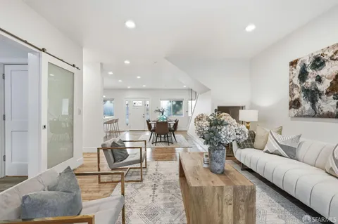 a living room with furniture and view of kitchen