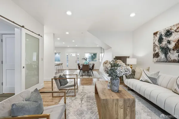 a living room with furniture and view of kitchen
