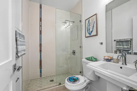 a bathroom with a sink a toilet and shower