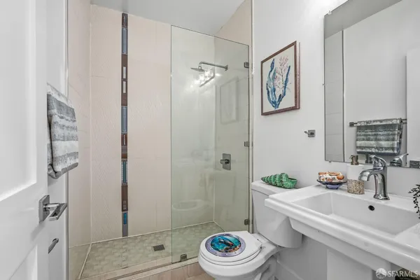 a bathroom with a sink a toilet and shower