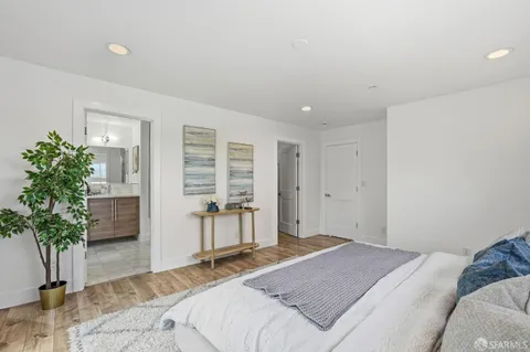 a spacious bedroom with a bed and a potted plant