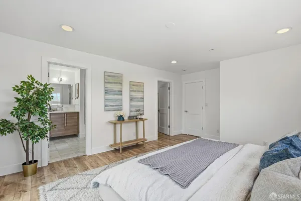 a spacious bedroom with a bed and a potted plant