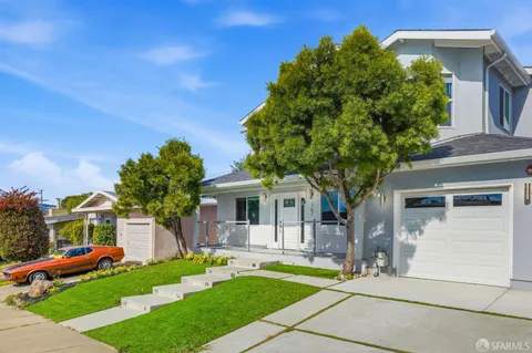 a front view of a house with a garden and plants