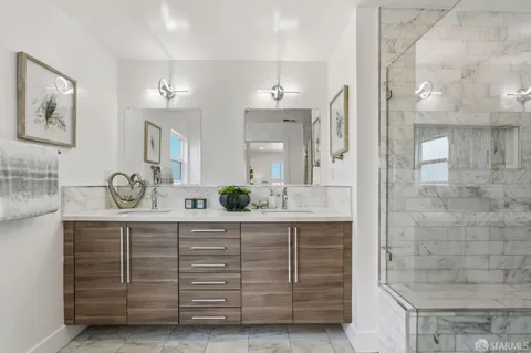 a bathroom with a granite countertop sink a mirror and a shower
