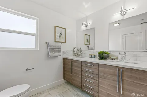 a spacious bathroom with a granite countertop sink mirror and a toilet