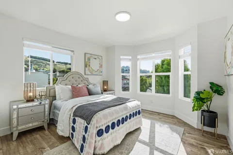 a bedroom with a large bed and a potted plant