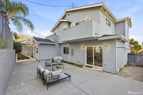 a view of a patio with a table and chairs and potted plants