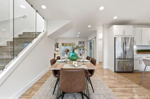 a dining room with stainless steel appliances furniture a refrigerator and kitchen view