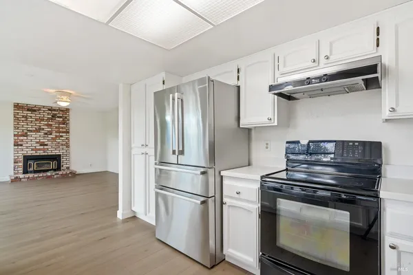 a kitchen with stainless steel appliances white cabinets and a stove top oven