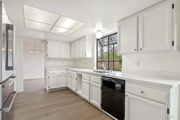 a kitchen with granite countertop white cabinets and white appliances