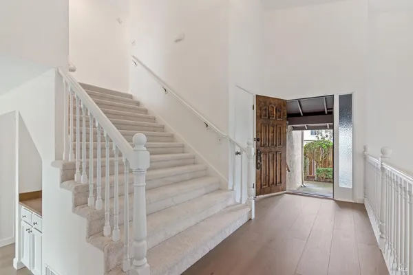 a view of a hallway with wooden floor and entryway