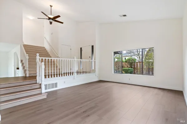 a view of a room with wooden floor fan and a window