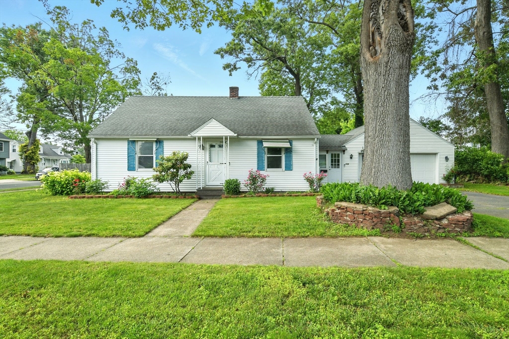 a front view of a house with a yard and plants
