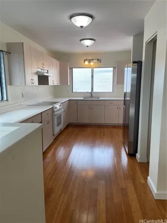 a kitchen with wooden floors and white cabinets