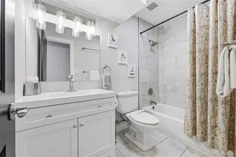 a bathroom with a sink toilet a mirror and shower