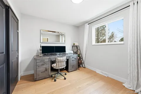 a view of a workspace with furniture and a window