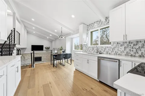 a living room with stainless steel appliances kitchen island granite countertop furniture a sink a stove a microwave and wooden floor