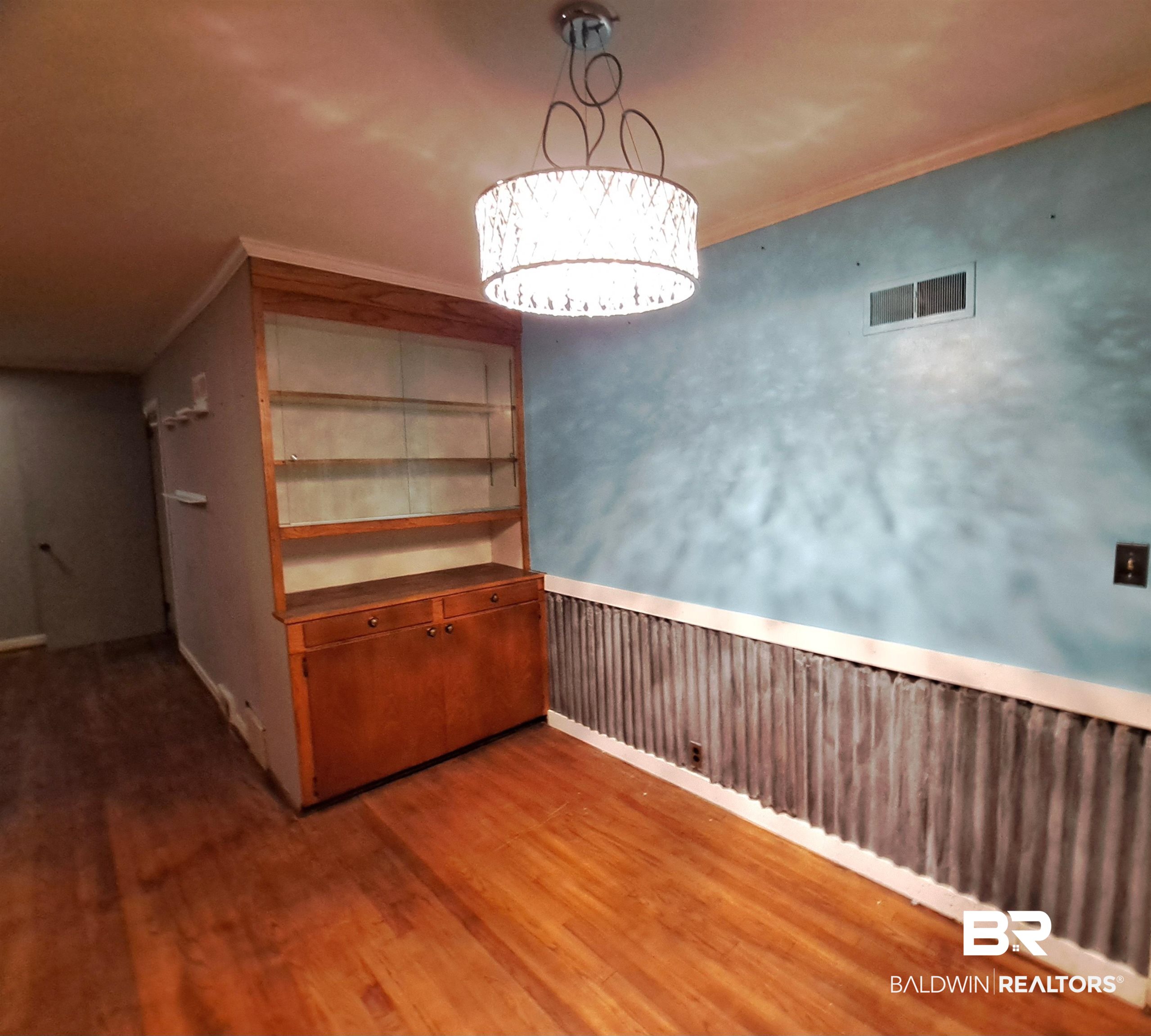 249 Newton Parkway Evergreen, AL 36401 - Photo 22 of 28 Unfurnished dining area featuring a wainscoted wall, light wood-style floors, and crown molding