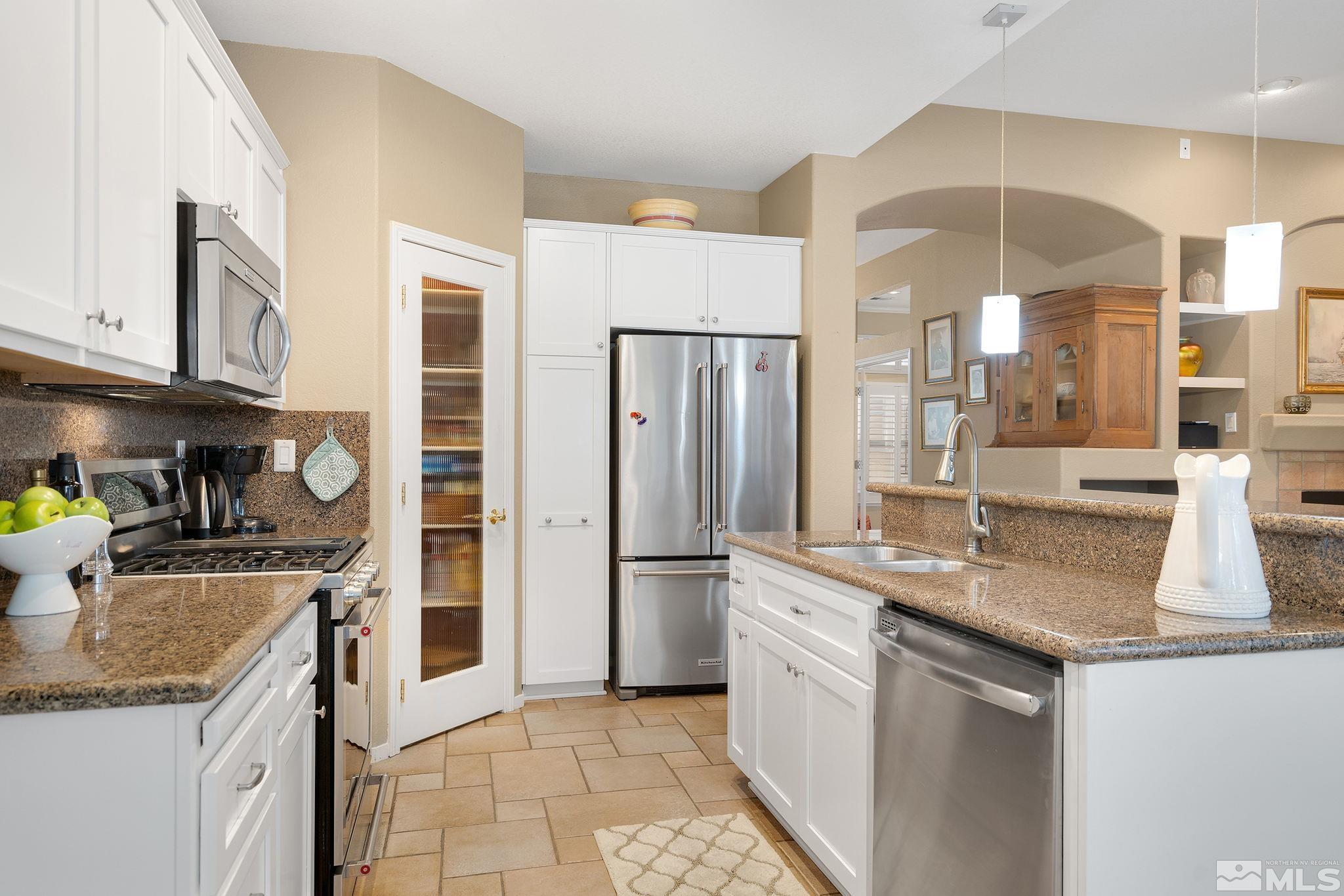 1700 Comanche Moon Drive Reno, NV 89521 - Photo 17 of 34 a kitchen with stainless steel appliances granite countertop a sink stove and refrigerator