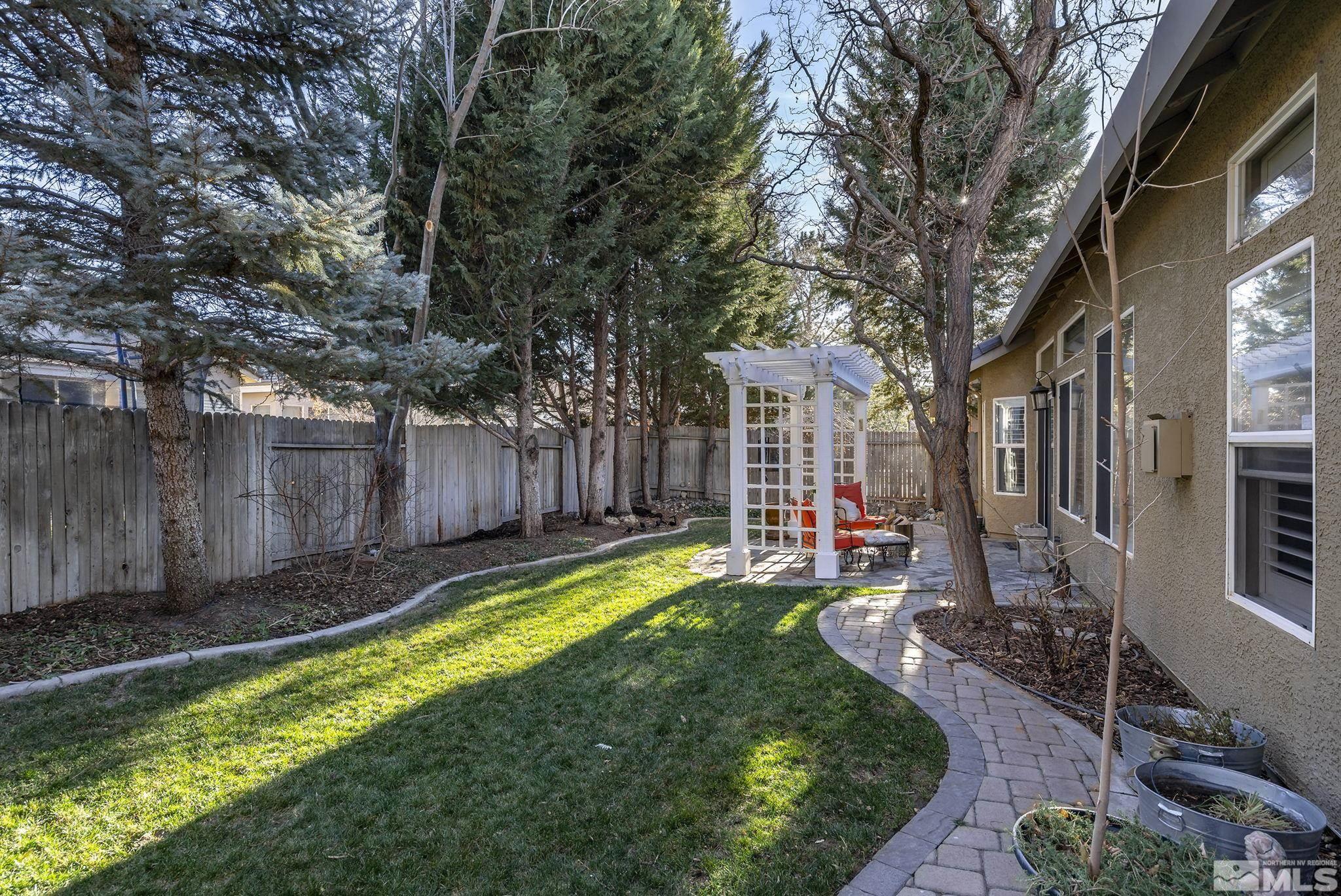 1700 Comanche Moon Drive Reno, NV 89521 - Photo 32 of 34 a view of a backyard with table and chairs and a large tree