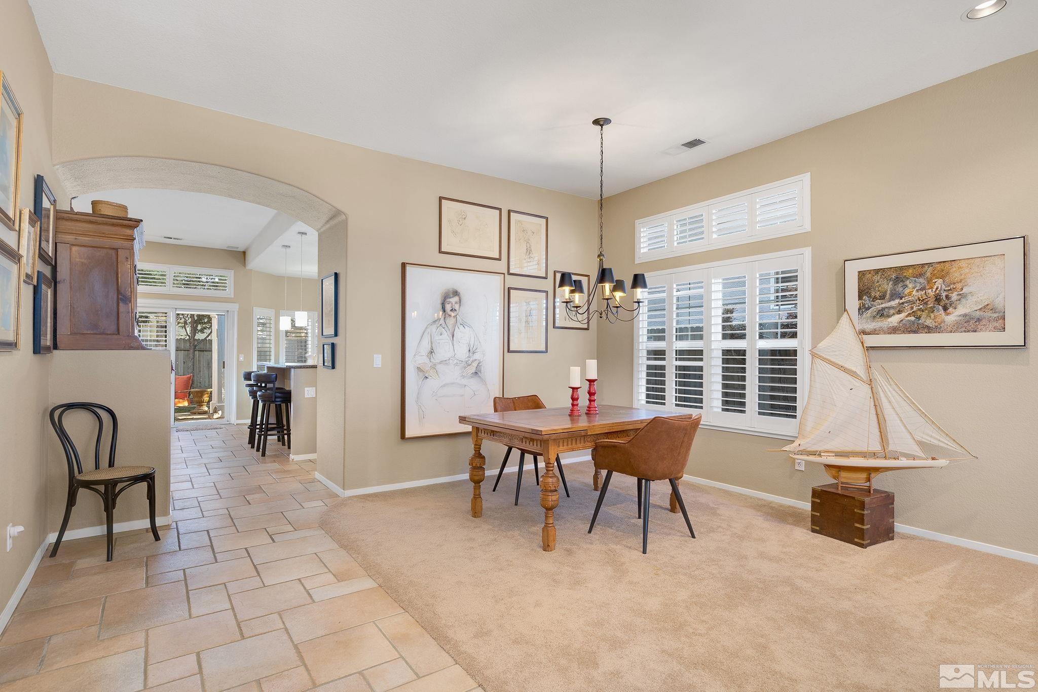 1700 Comanche Moon Drive Reno, NV 89521 - Photo 7 of 34 a living room with furniture a dining table and a chandelier