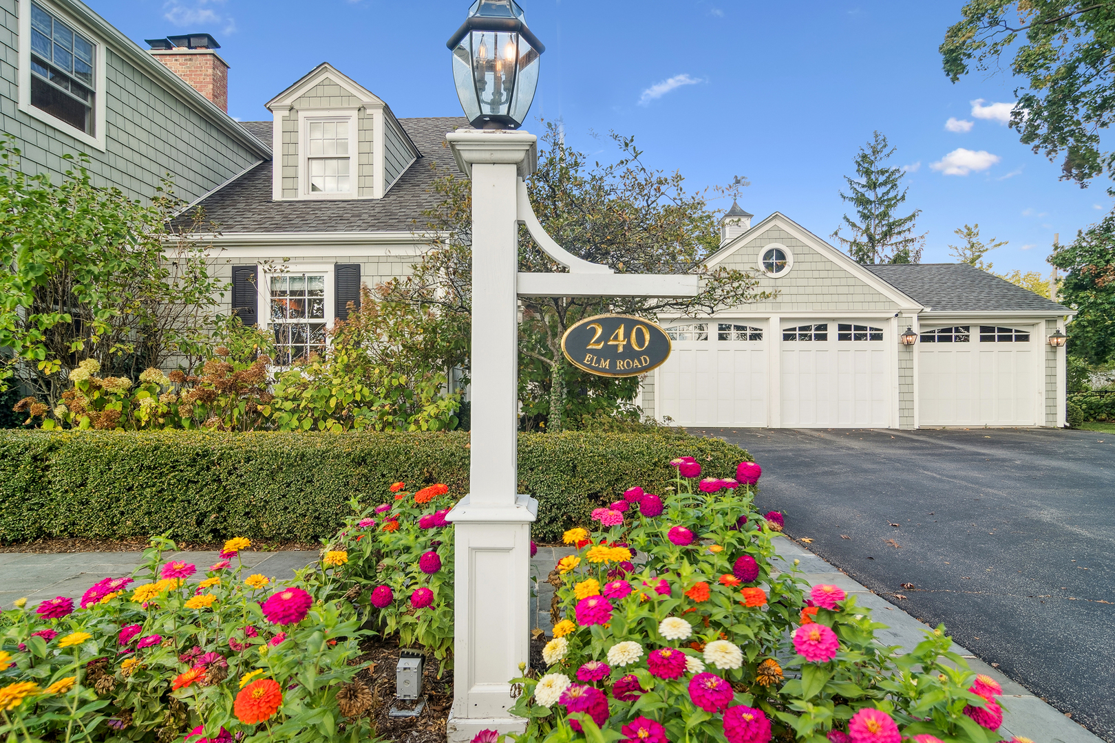 240 Elm Road Barrington, IL 60010 - Photo 2 of 56 a front view of a house with lots of flowers and trees