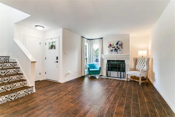 a view of a livingroom with wooden floor and a fireplace