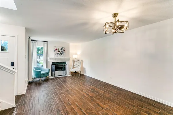 a view of a livingroom with wooden floor a fireplace and window