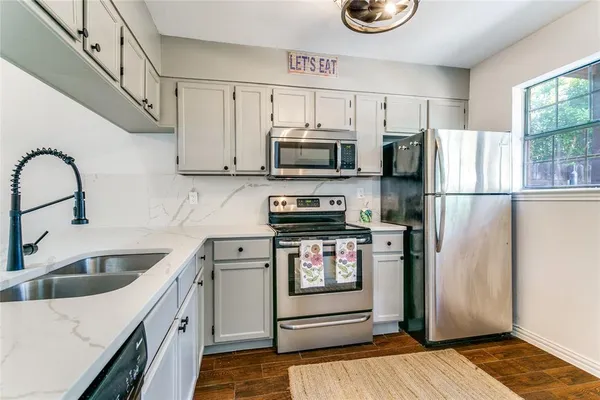a kitchen with stainless steel appliances a stove a sink and a refrigerator