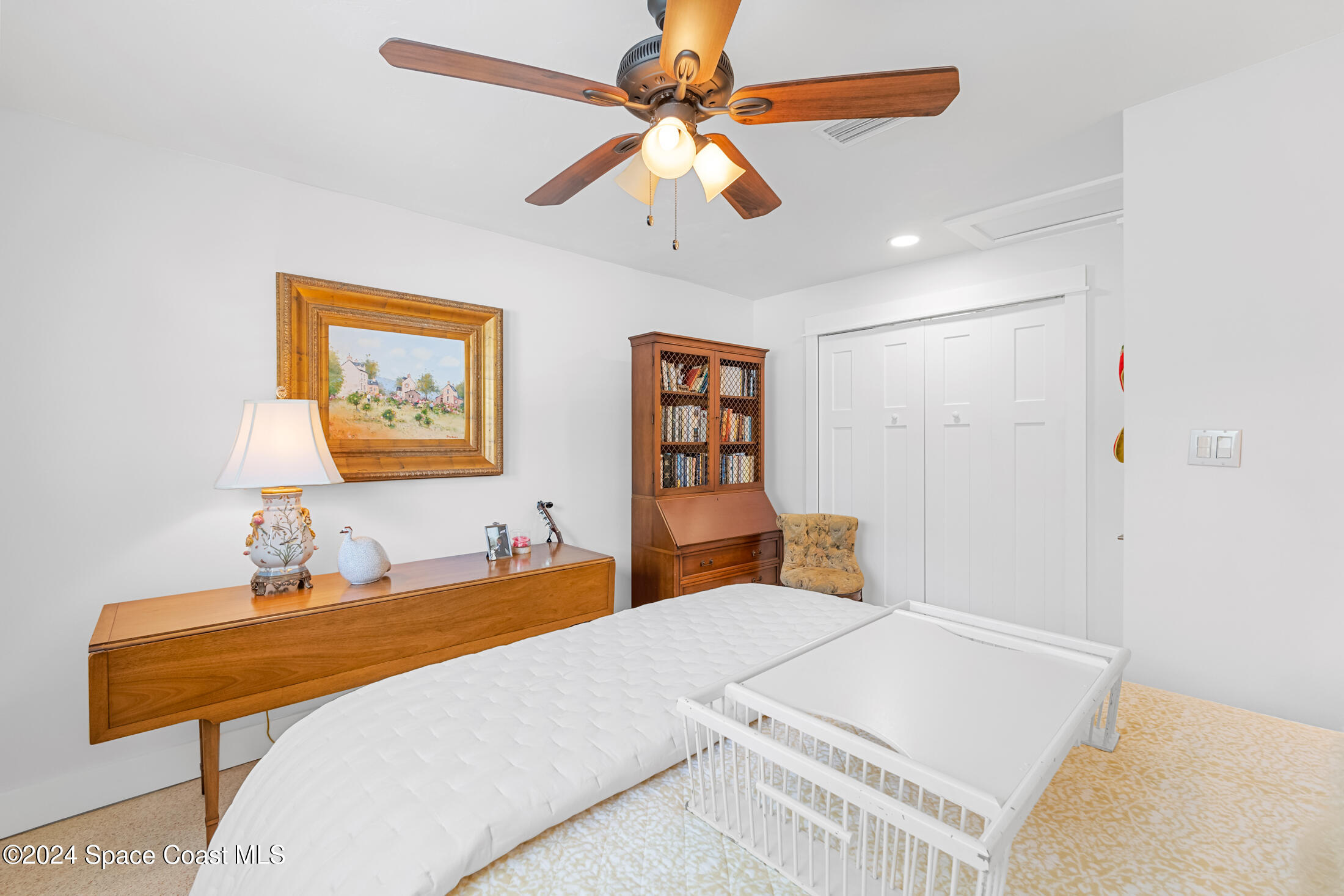 2051 Bali Road Cocoa Beach, FL 32931 - Photo 13 of 33 a bedroom with a bed and a chandelier