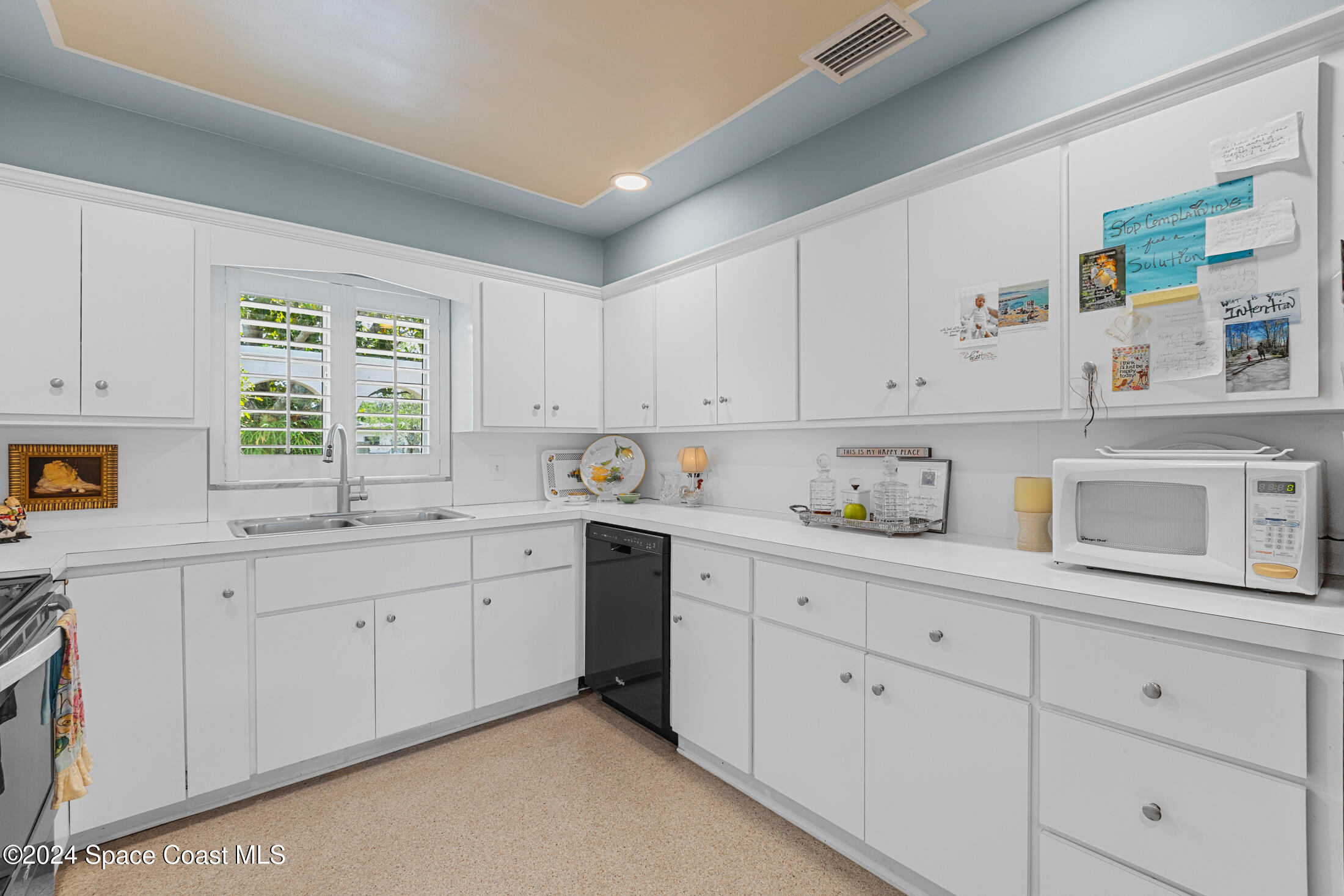 2051 Bali Road Cocoa Beach, FL 32931 - Photo 17 of 33 a kitchen with white cabinets and window