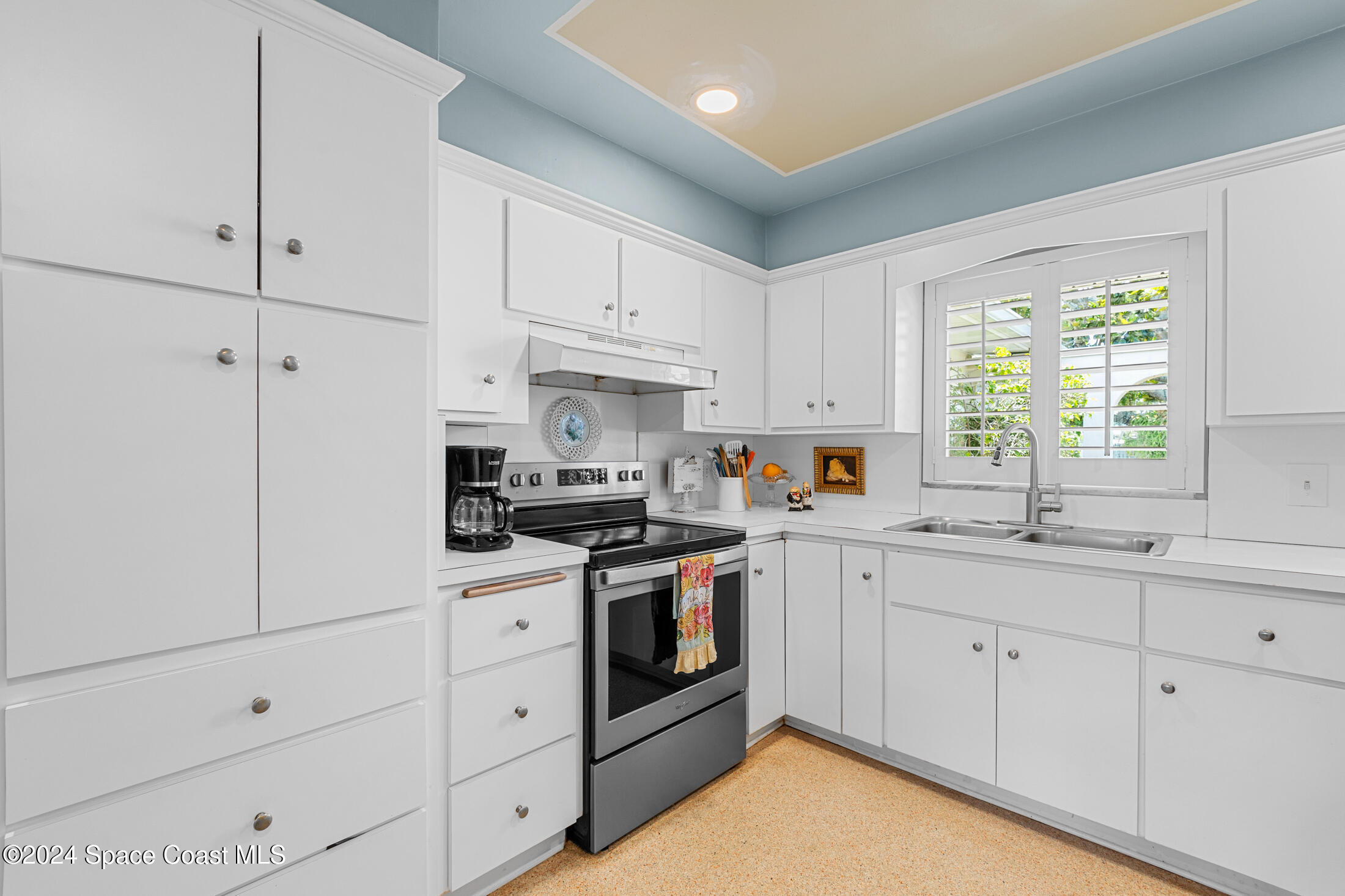 2051 Bali Road Cocoa Beach, FL 32931 - Photo 18 of 33 a kitchen with white cabinets and white appliances