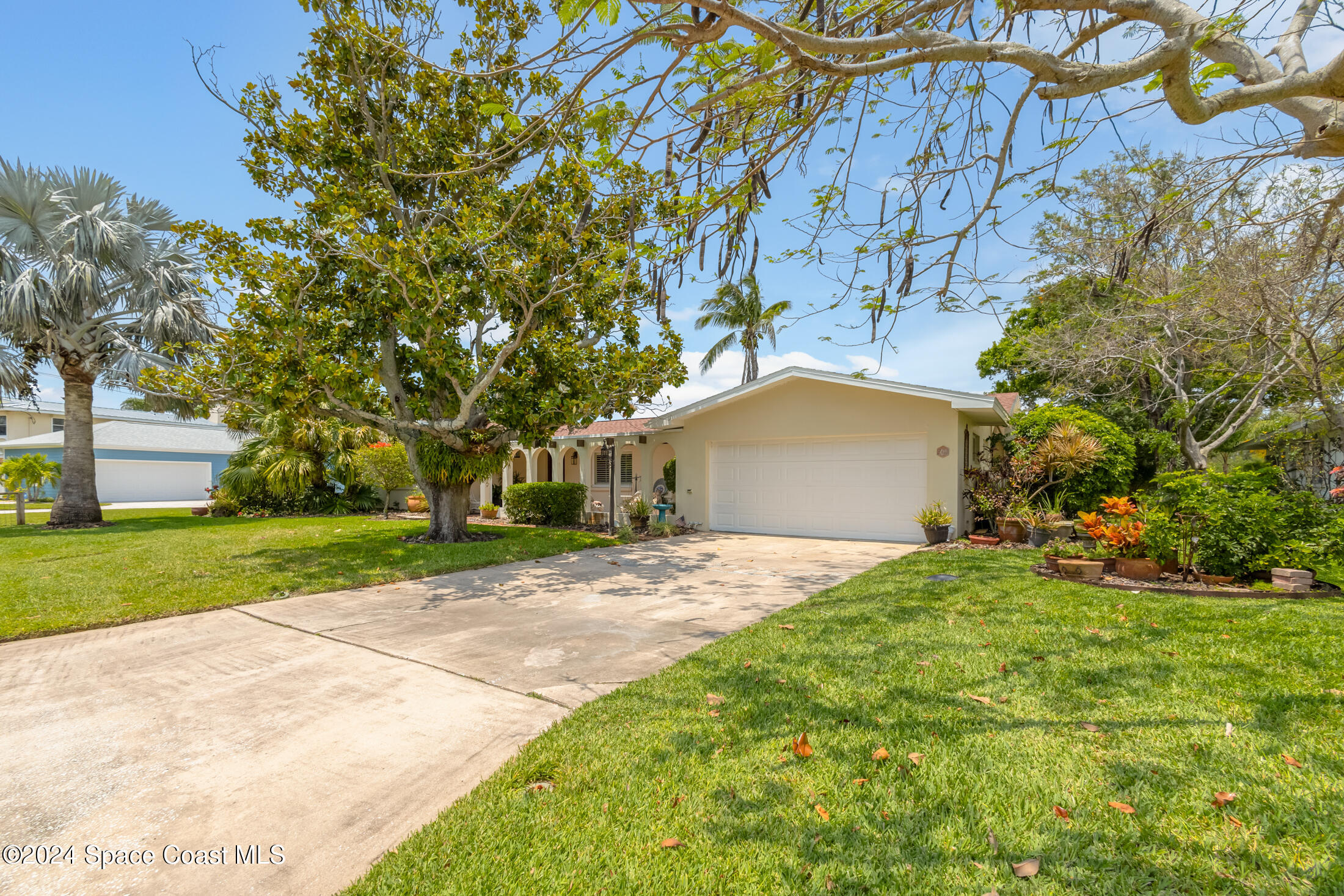 2051 Bali Road Cocoa Beach, FL 32931 - Photo 20 of 33 a front view of a house with a yard and garage