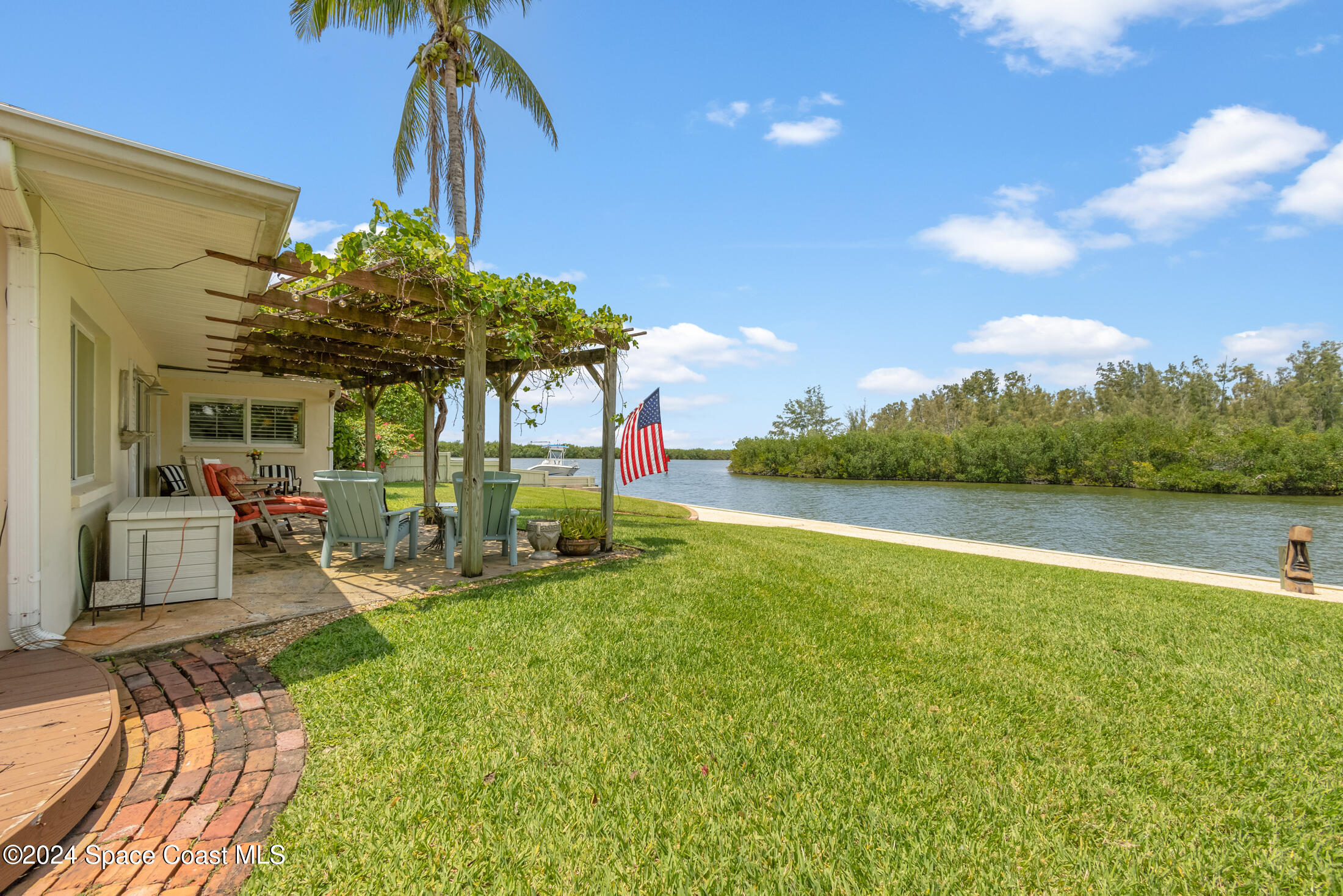 2051 Bali Road Cocoa Beach, FL 32931 - Photo 26 of 33 a view of a patio with table and chairs under an umbrella