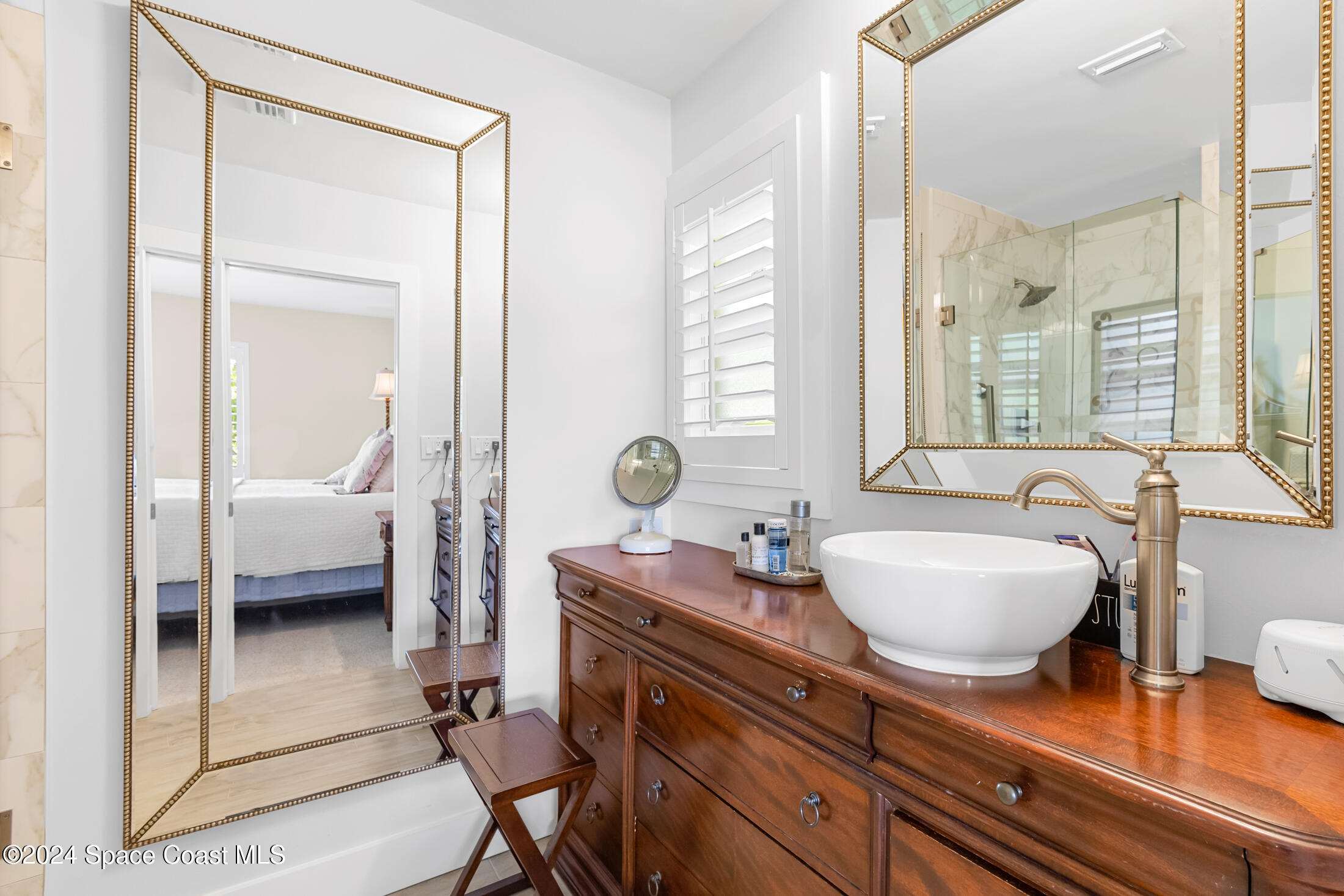 2051 Bali Road Cocoa Beach, FL 32931 - Photo 9 of 33 a en suite bathroom with a granite countertop sink and a mirror