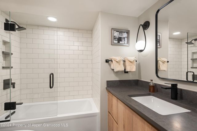 a bathroom with a granite countertop sink a toilet and bathtub