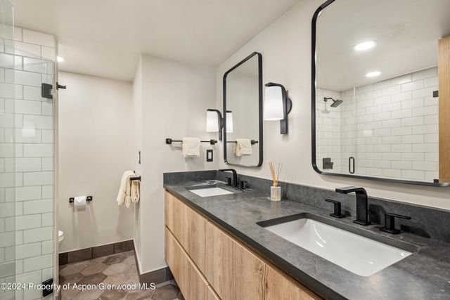 a bathroom with double vanity sink and mirror