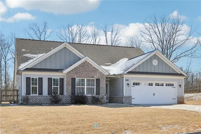 a front view of a house with a yard covered with snow