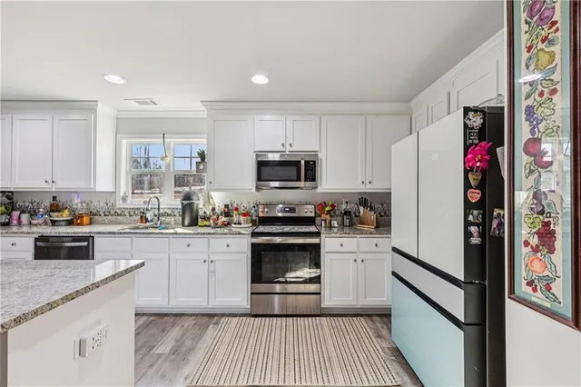 a kitchen with granite countertop a refrigerator stove and microwave