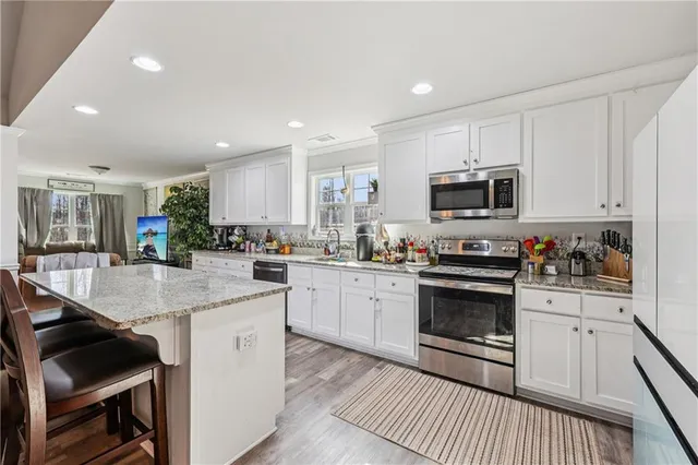 a kitchen with sink a microwave and cabinets
