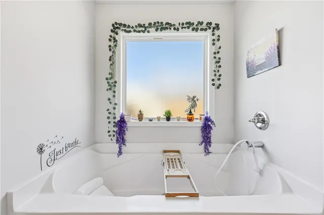 a bathroom with a bathtub sink and mirror