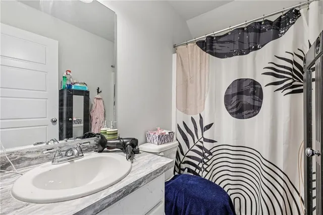 a bathroom with a sink a mirror a bathtub and a shower curtain