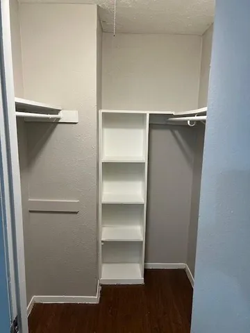 a view of walk in closet with empty racks