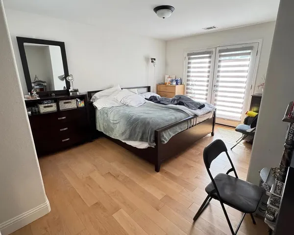 a bedroom with a bed window and chair