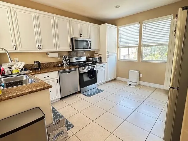 a kitchen with a sink a stove and cabinets