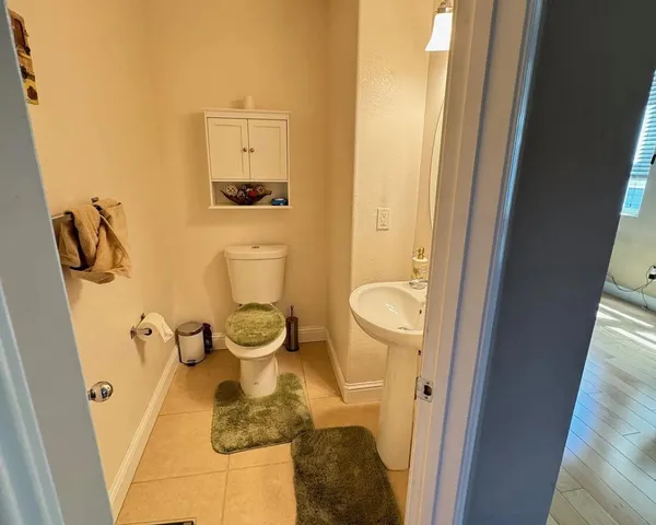 a bathroom with a granite countertop toilet and a sink