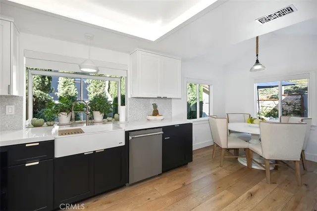 a kitchen with stainless steel appliances granite countertop a sink a stove a refrigerator cabinets and a window