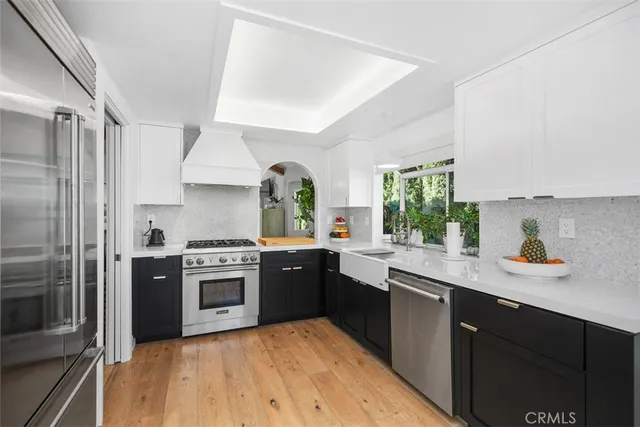 a kitchen with stainless steel appliances a stove a sink and a refrigerator