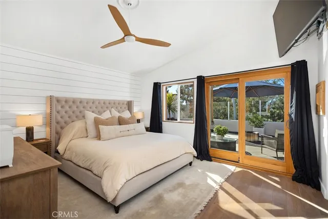 a bedroom with a large bed and wooden floor